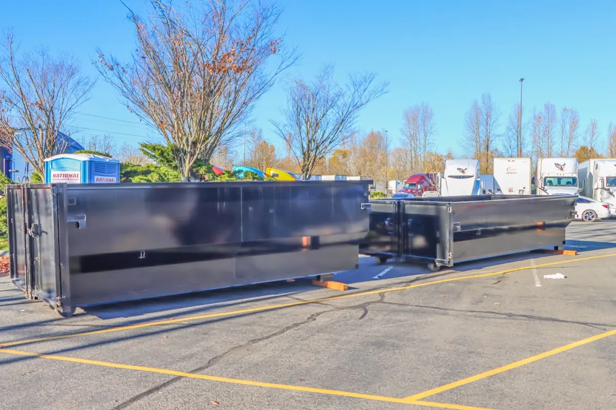 Professional dumpster rental service with roll-off container on residential driveway in Freehold